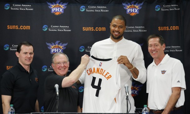 Flanked by Phoenix Suns head coach, Jeff Hornacek, right, general manager Ryan McDonough, left, and senior adviser Lon Babby, second from left, Suns' Tyson Chandler, the newly signed free agent, holds up his new uniform after being introduced to the media during a news conference Thursday, July 9, 2015, in Phoenix. (AP Photo/Ross D. Franklin)